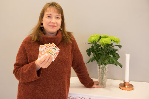 Kuvassa diakoniatyöntekijä Heli Mattila pitää käsissään lahjakortteja.