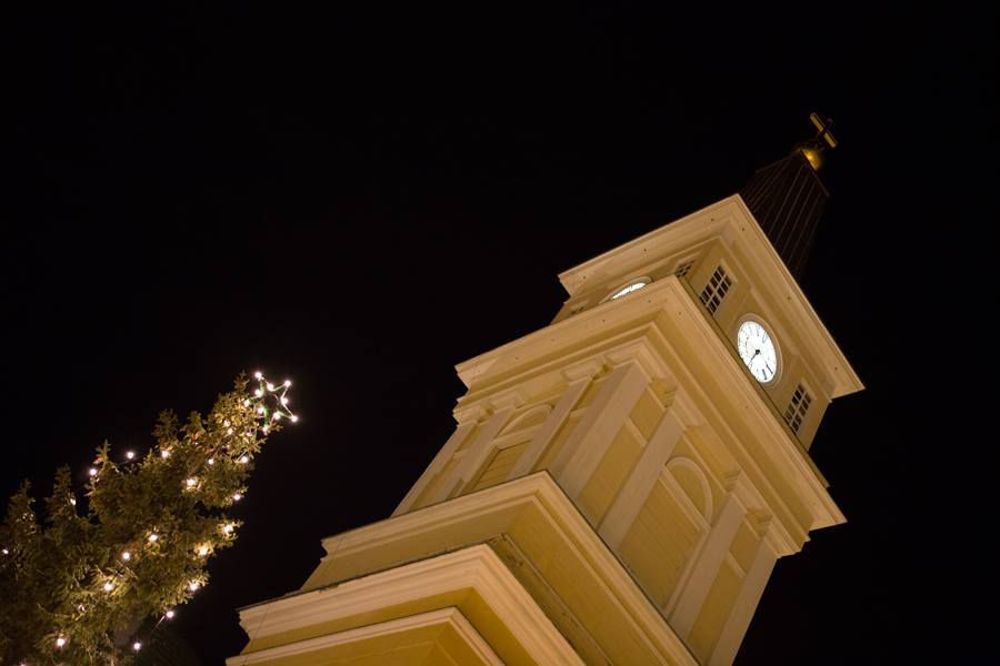 Oulun tuomiokirkko pimeässä kuvattuna, vierellä joulukuusi.