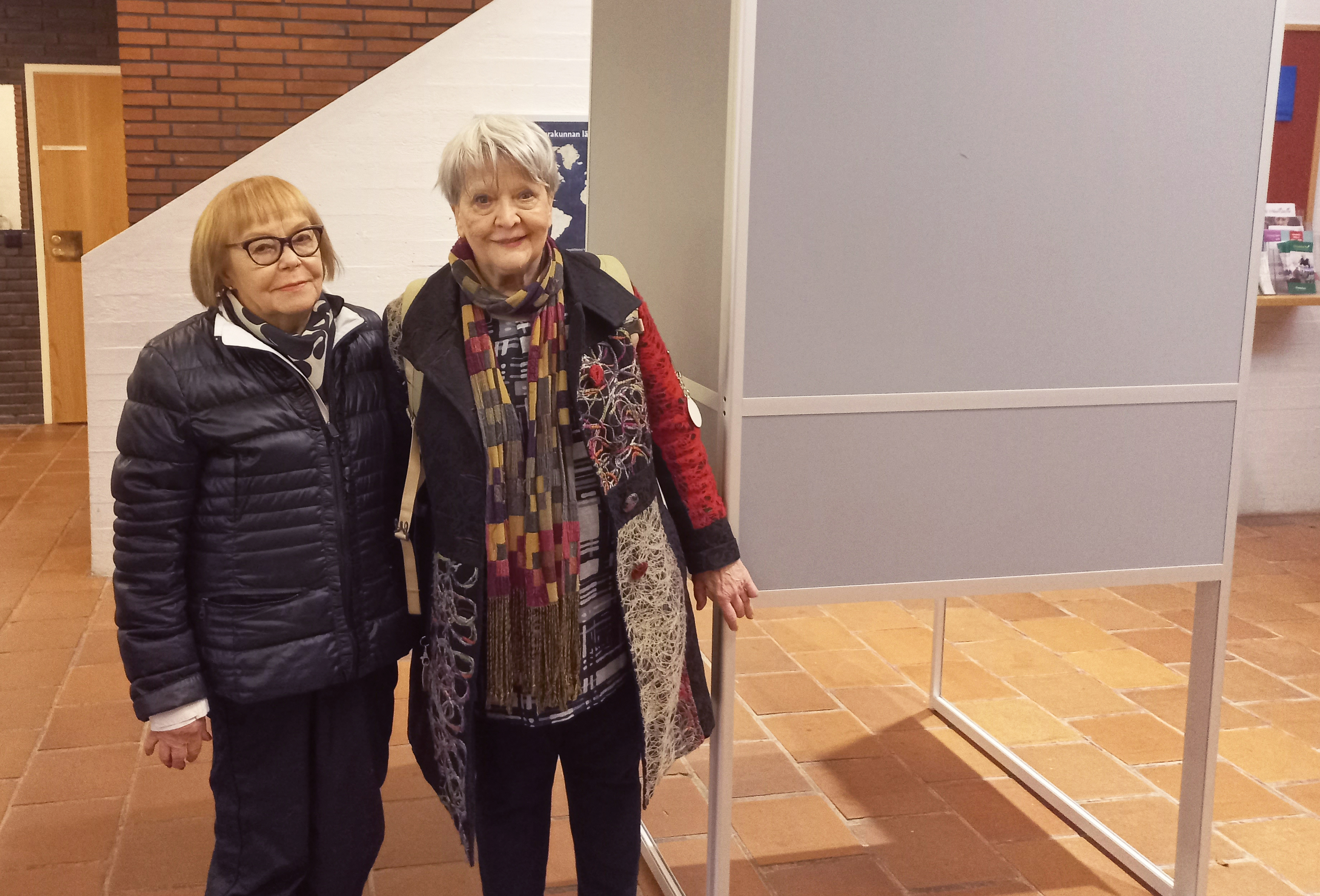 Ulla Törn ja Terttu Välikangas seisovat äänestyskopin vieressä ja katsovat kameraan.