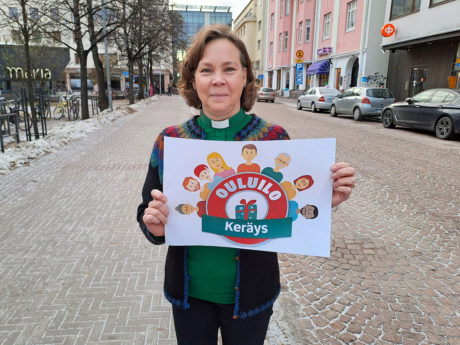 Marja Posio seisoo Isokadulla kädessään Ouluilo mainos