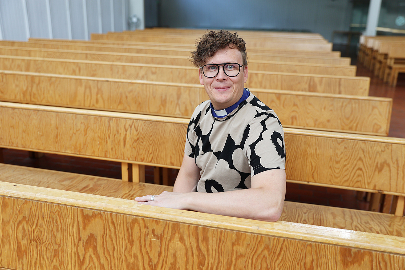 Nuorisotyönohjaaja Matti Ketola istuu Pyhän Tuomaan kirkkosalissa.