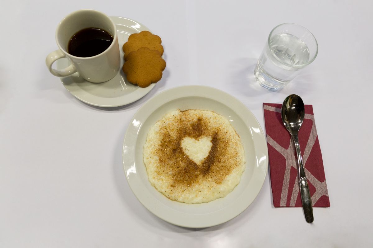 Puurolautanen, jossa on kanelilla muotoiltu sydän keskellä. Lautasen sivulla on lusikka, vesilasi ja kahvik...