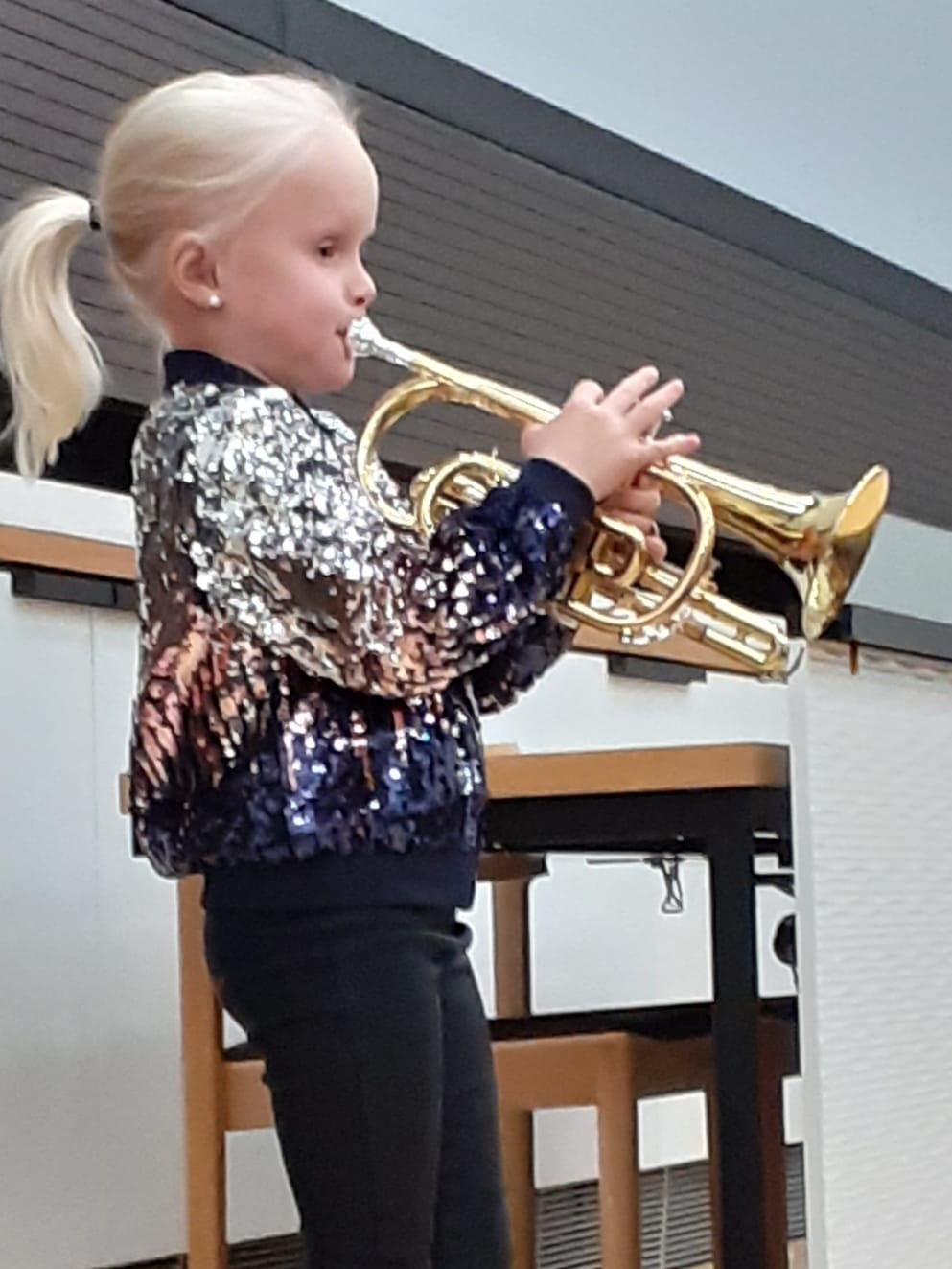 Tyttö soittaa trumpettia musiikkikoulussa.