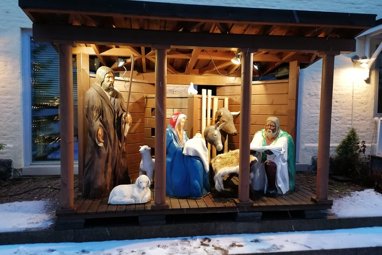 Kuvassa isokokoinen seimi, jossa on puusta veistetyt ihmishahmot.