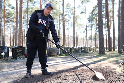 Kuvassa on haudan pintaa tasoittava Juuso Kallio.