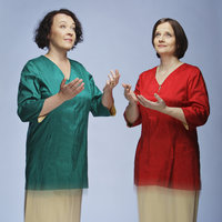 Kuvassa on Johanna Korhonen ja Hilkka-Liisa Vuori, jotka laulavat ja kohottavat käsiään.