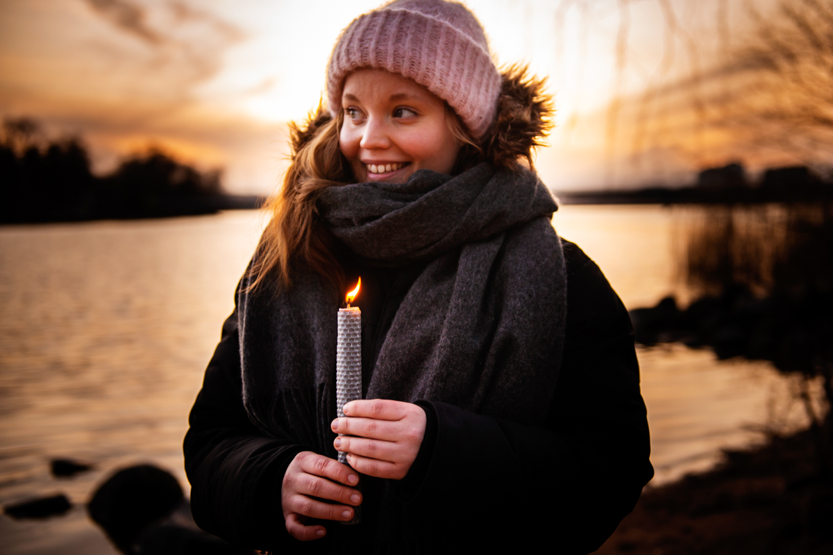 Earth Hour -kampanjakuva, nuorella naisella kynttilä kädessä