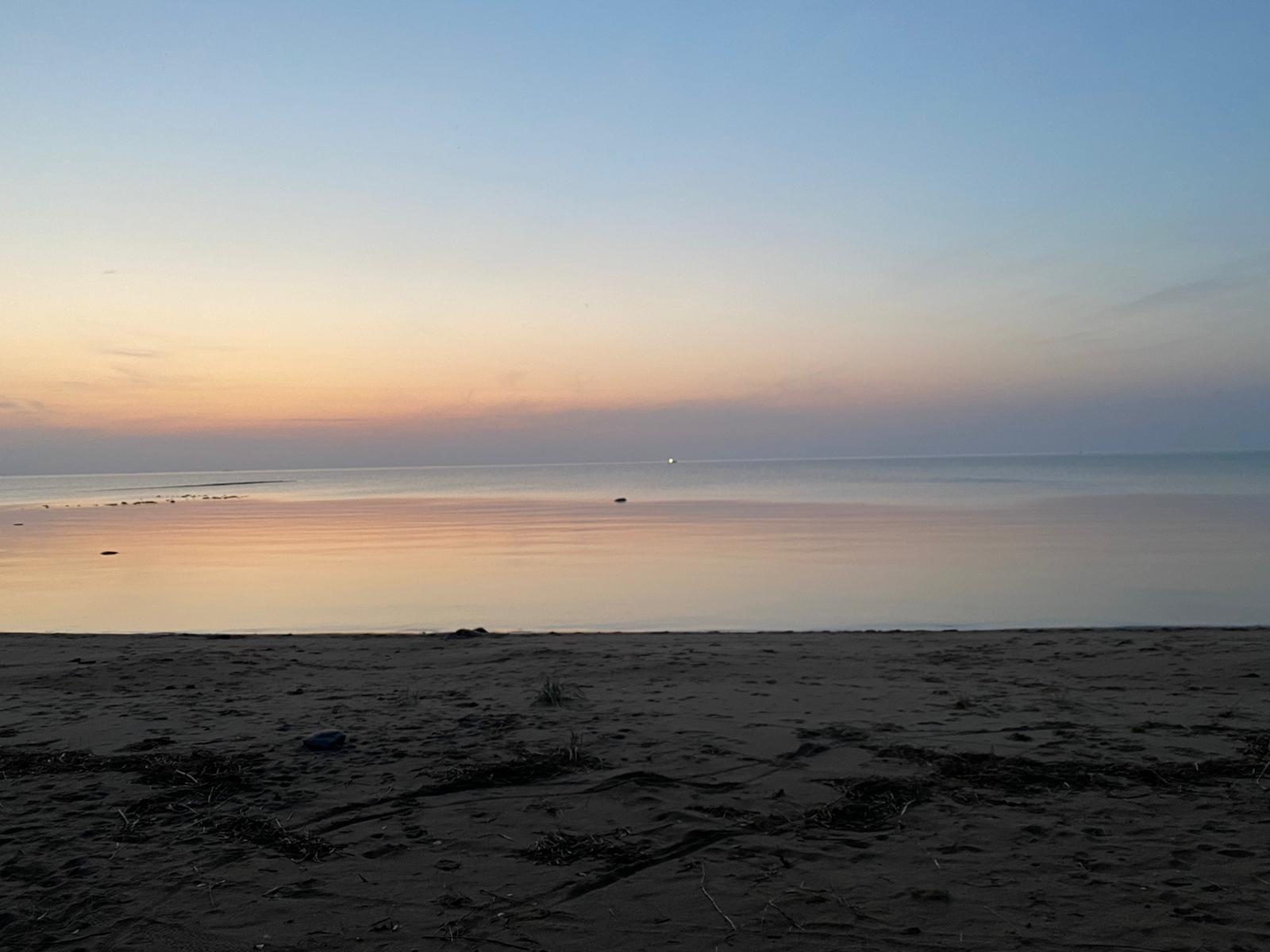 Seiskojen leiri Kuvassa aavaa merimaisemaa auringon laskiessa