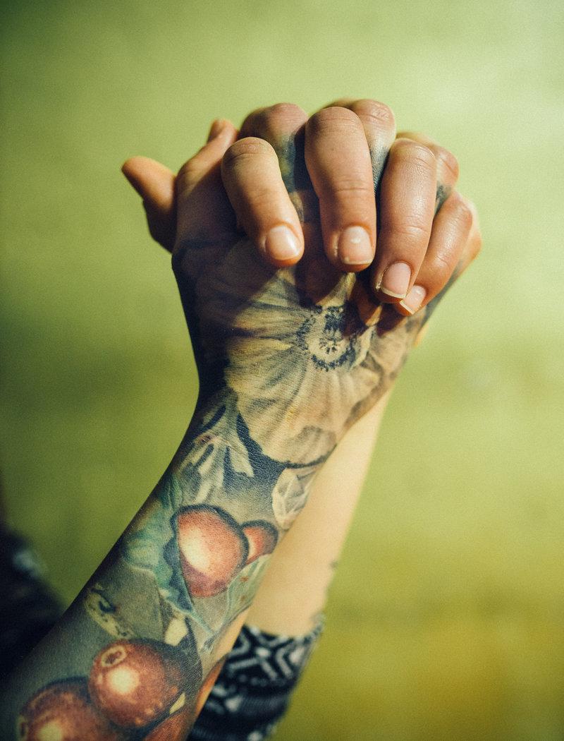 Tatuoidut kädet ristissä