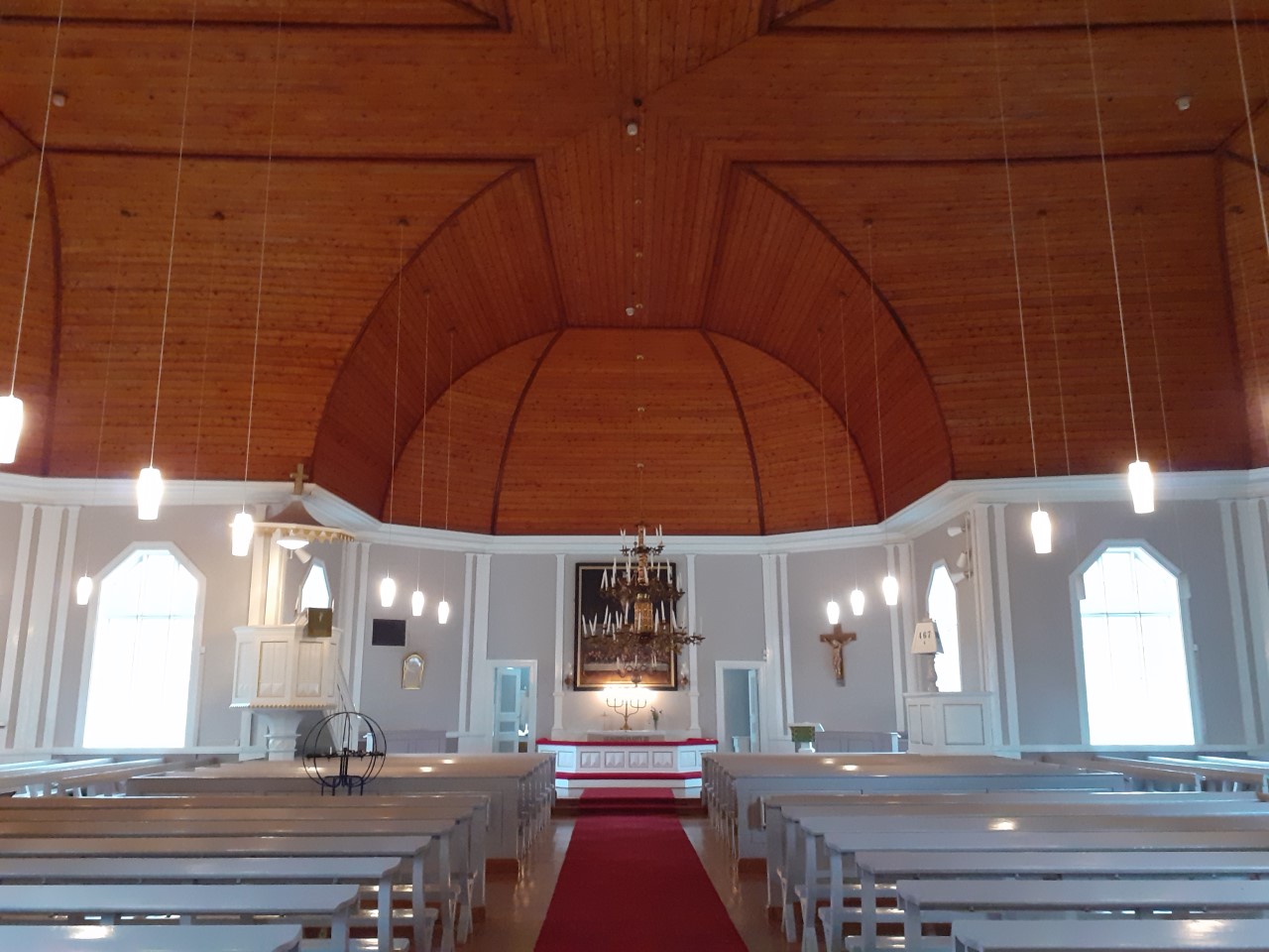 Säräisniemi Church form the inside. Light benches and walls, red-brown ceiling. 