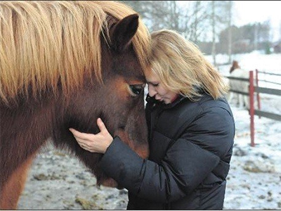 Nainen halaa hevosta.