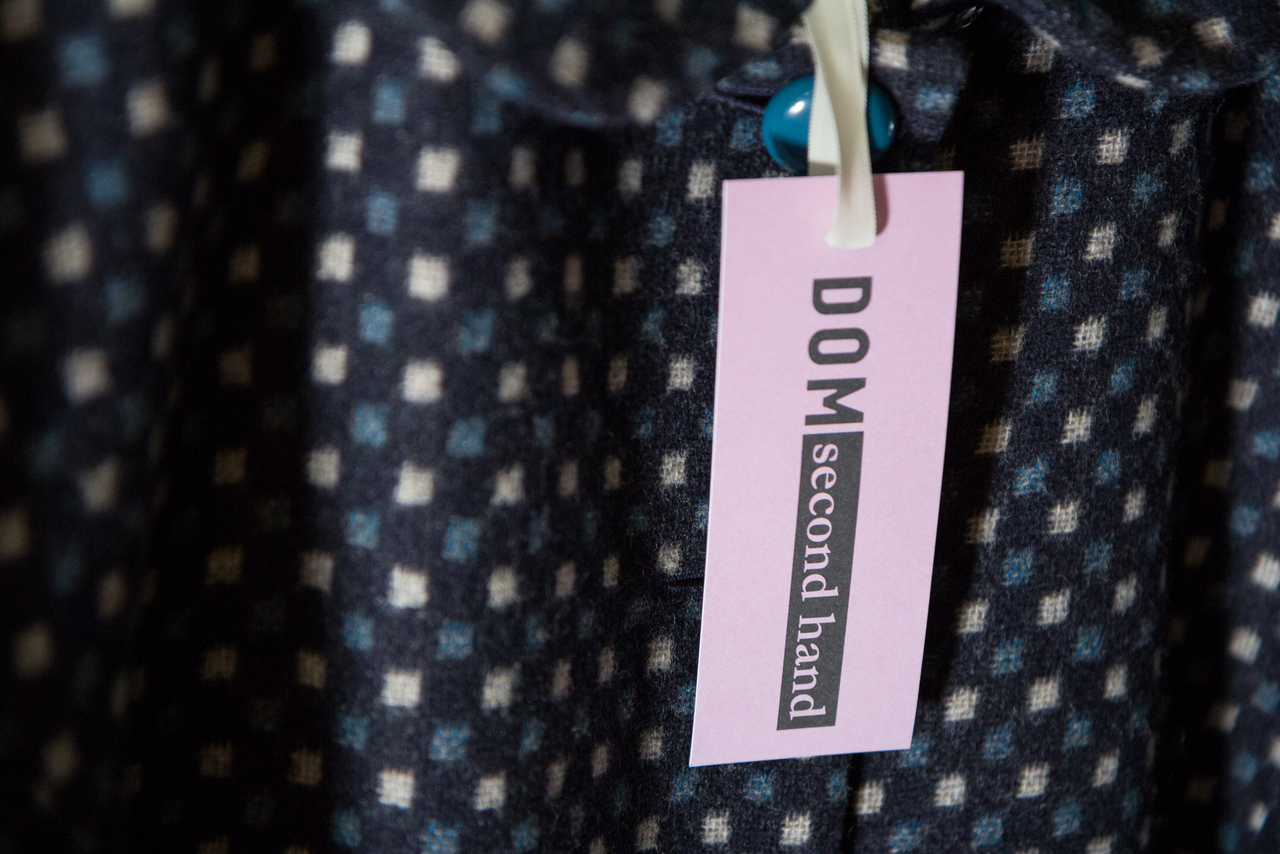 Domin hintalappu, joka on kiinni tekstiilissä.
